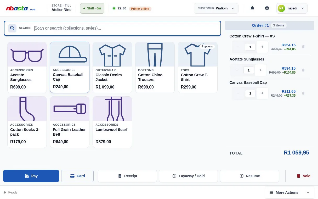 The Abosto till set up for a clothing shop: eight product tiles including a Cotton Crew T-Shirt marked five options, and a three-line sale on the right totalling R1 059,95 whose first line is that T-shirt in XS.